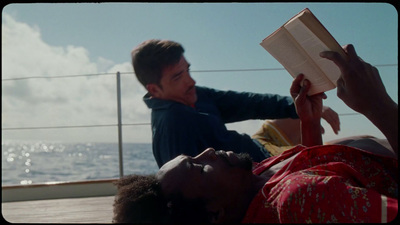 a man laying on the ground reading a book