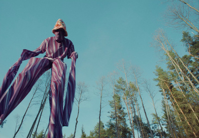 a woman in a purple and white striped outfit flying through the air