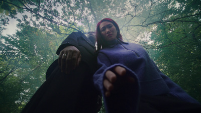 a woman standing in the middle of a forest