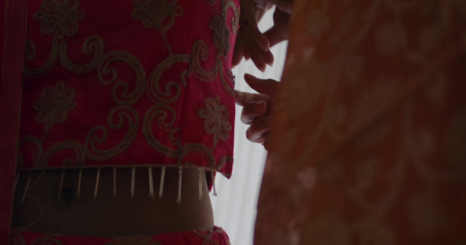 a close up of a red and gold dress