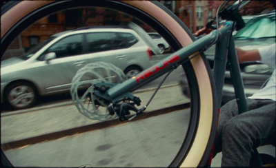 a rear view mirror on a bicycle with a car in the background