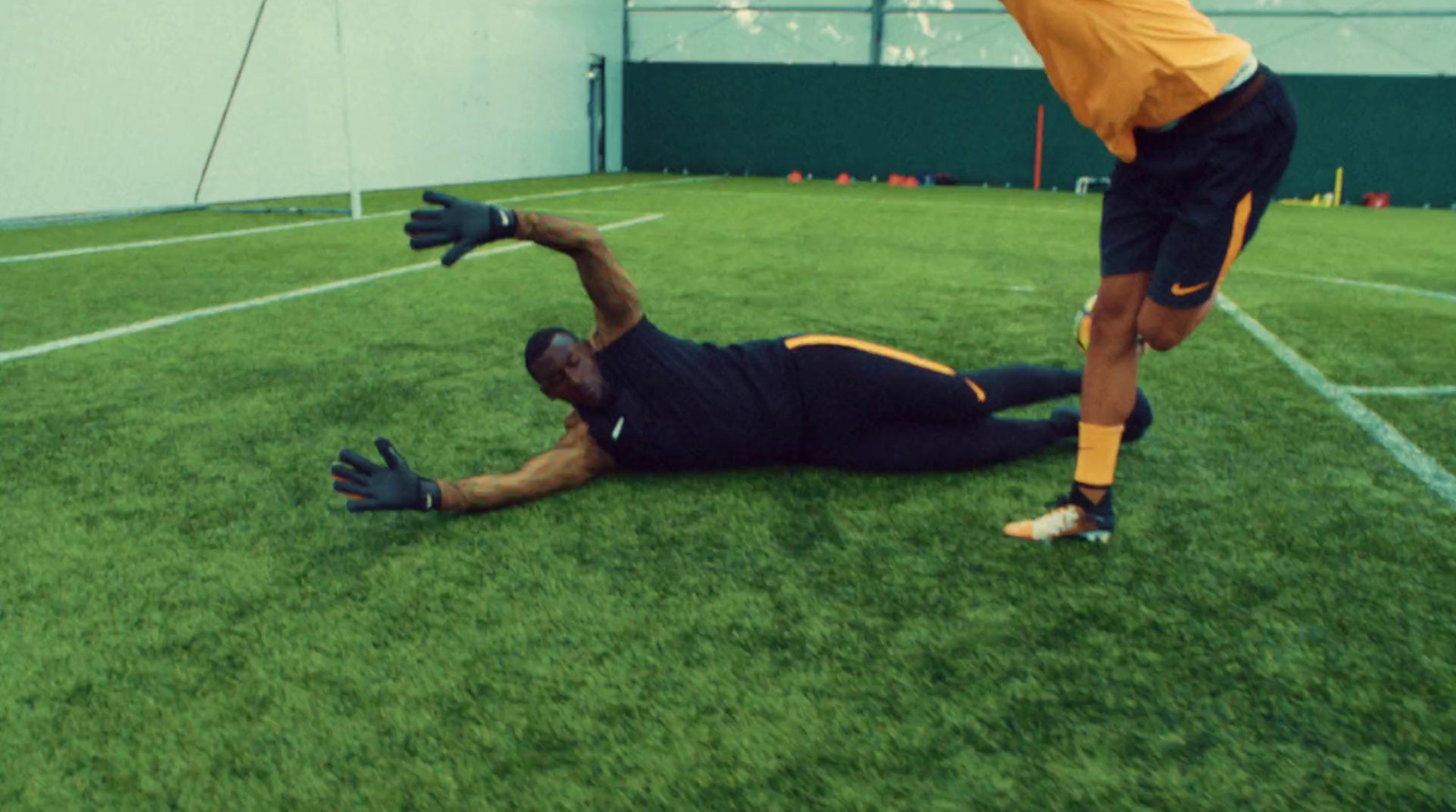 a man laying on the ground with a soccer ball