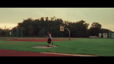 a person is running on a field with a basketball hoop