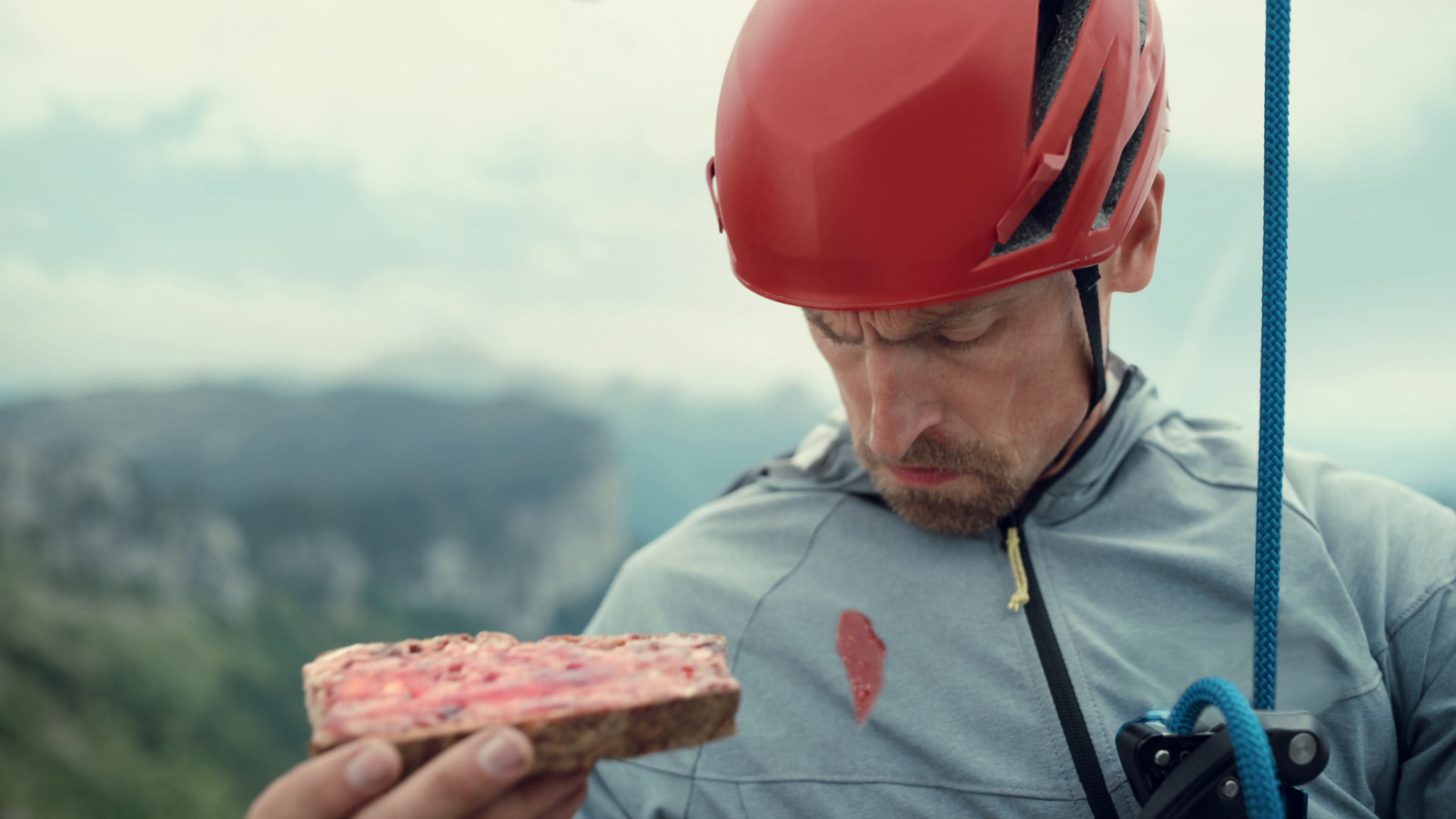 a man in a helmet eating a piece of pizza