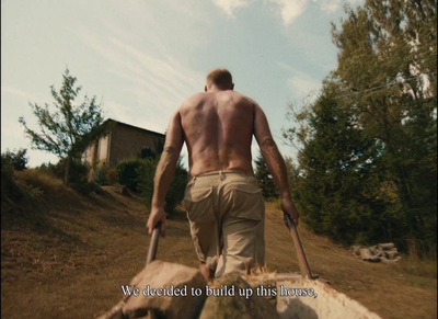 a man walking down a hill with a dog