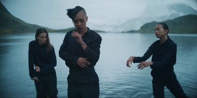 a group of people standing next to a body of water