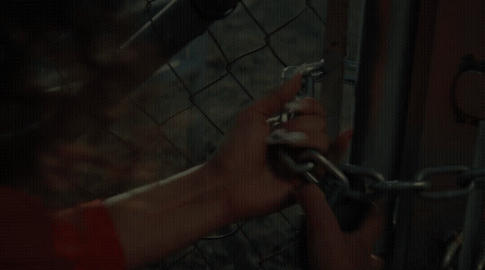 a person is holding a chain on a fence