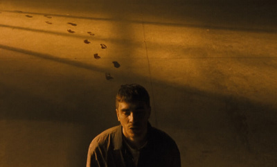 a man standing in front of a wall with footprints on it