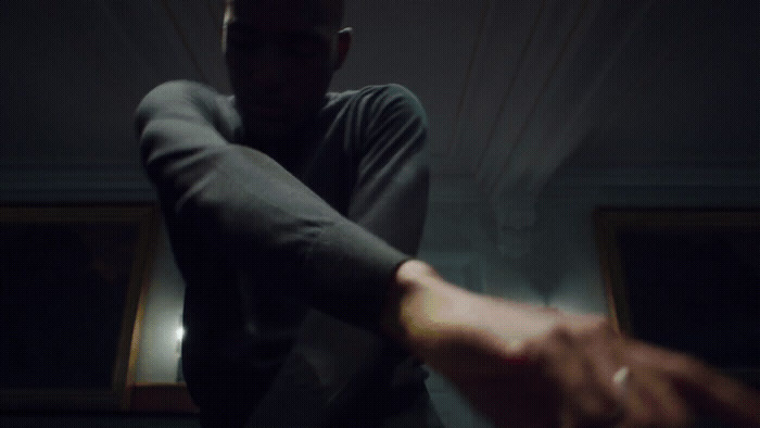 a man holding a woman's hand in a dark room