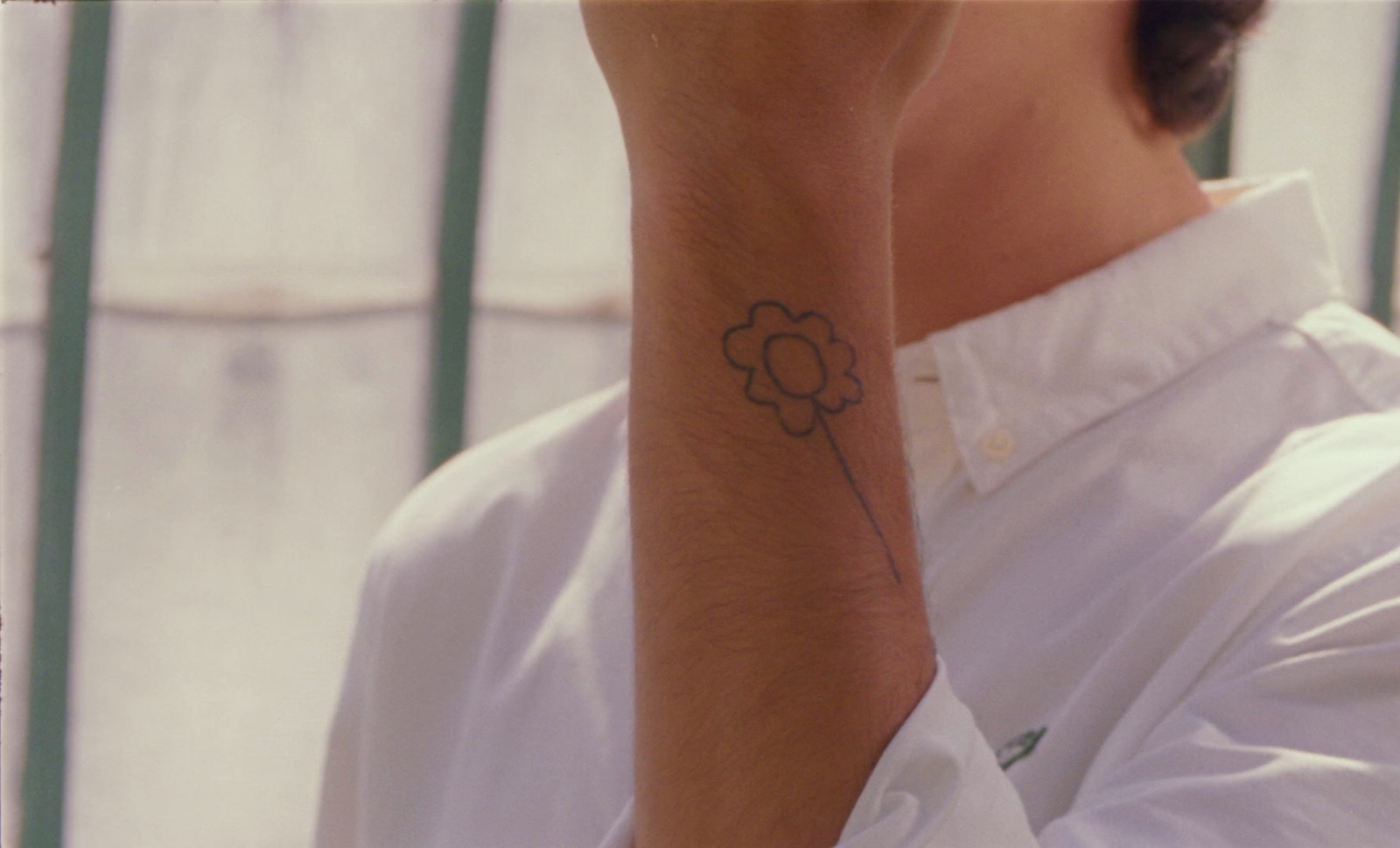 a man with a flower tattoo on his arm