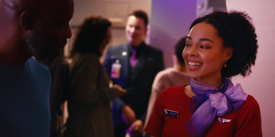 a woman wearing a purple scarf standing in front of a group of people