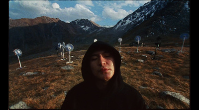 a man in a hoodie standing in a field