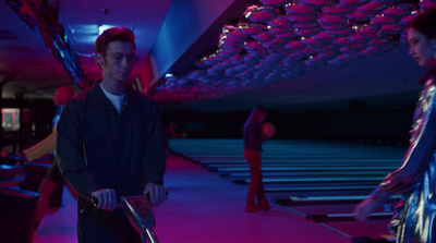 a man riding a scooter in a bowling alley