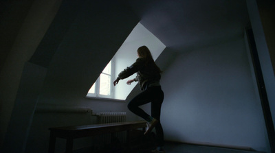 a woman standing in a dark room with a window