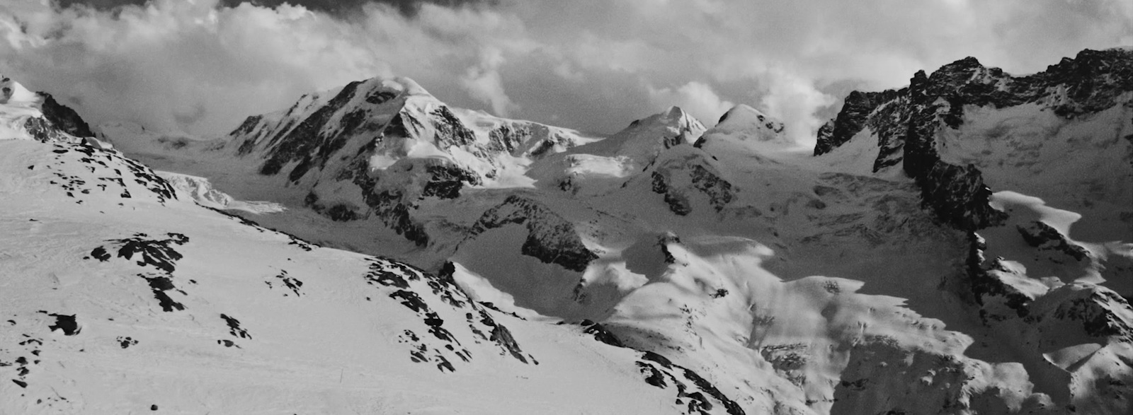 a black and white photo of snow covered mountains