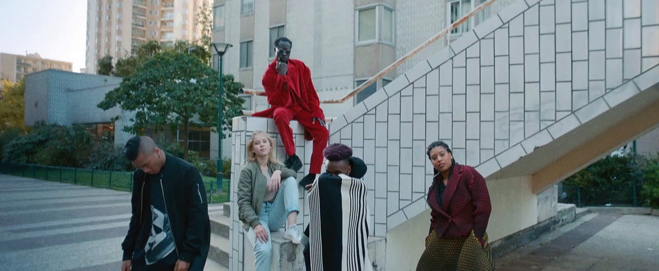 a group of people walking down a street next to a building