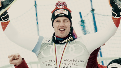 a man holding a pair of skis up in the air