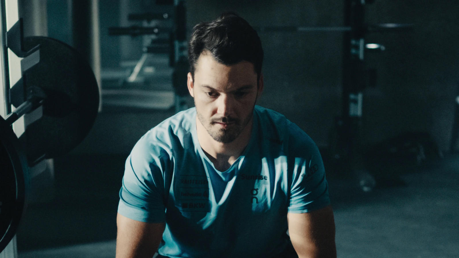 a man in a blue shirt sitting in a gym