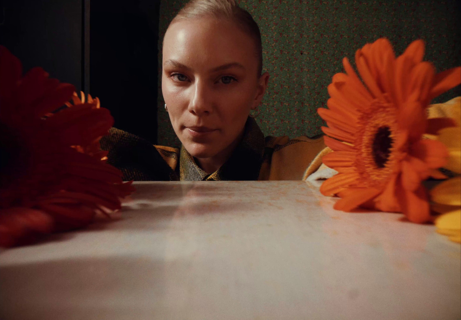 a woman sitting at a table with flowers in front of her