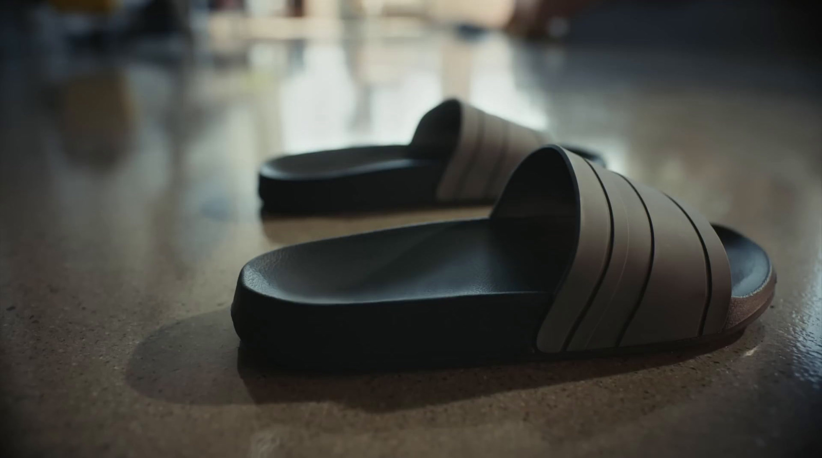 a pair of black and white slippers sitting on top of a wooden floor