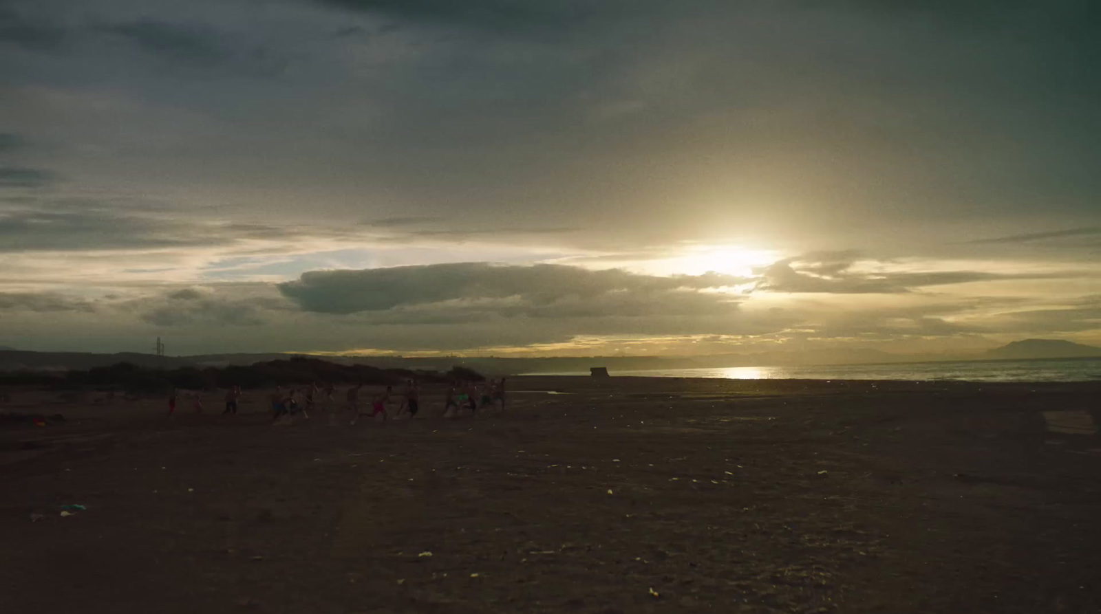 a group of people standing on top of a sandy beach