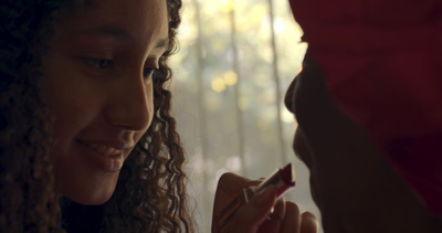 a woman with curly hair holding a cigarette