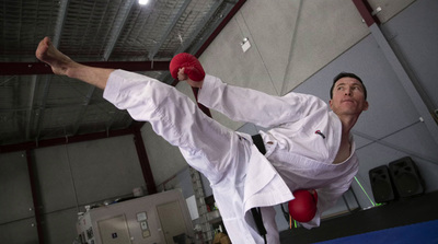 a man in a white karate suit doing a kick