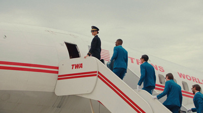 a group of people walking up the stairs of a plane