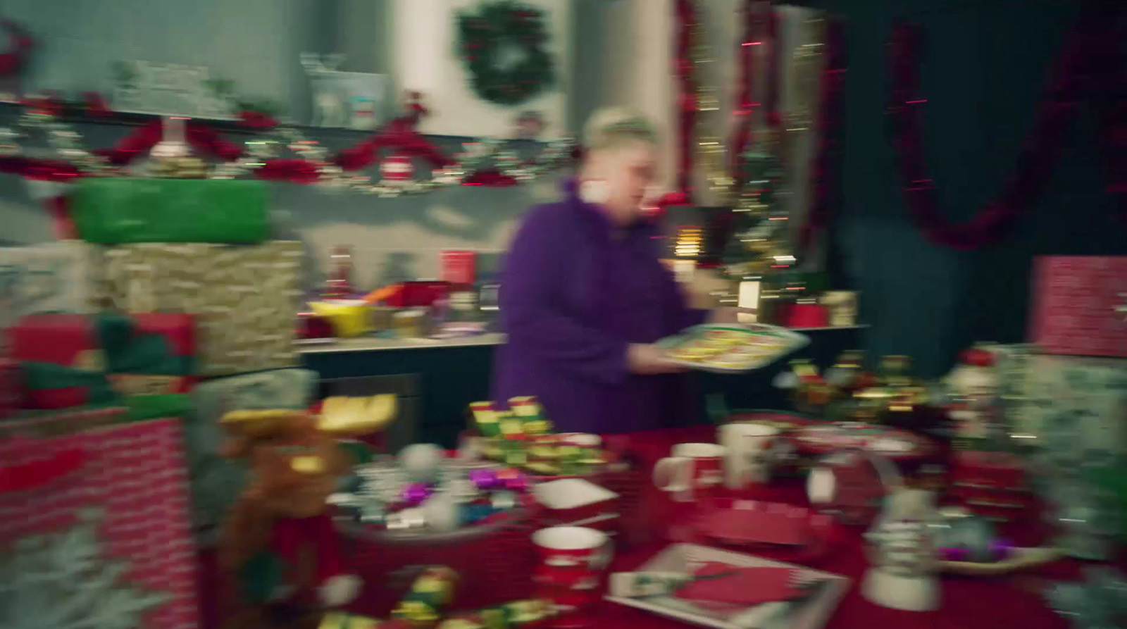 a woman standing in a room filled with christmas presents