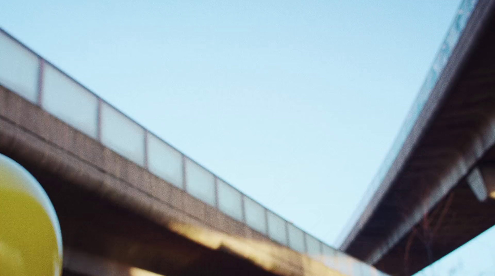 a close up of a traffic light with a bridge in the background