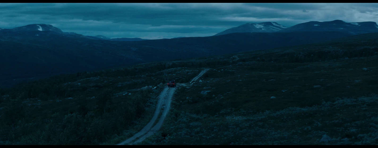 a car driving down a road in the mountains