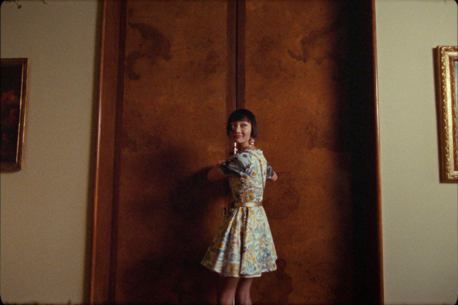 a little girl standing in front of a wooden door