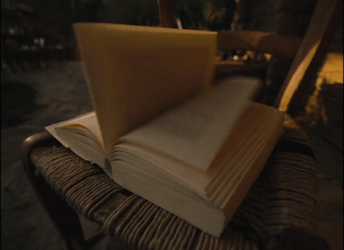 an open book sitting on top of a wooden chair