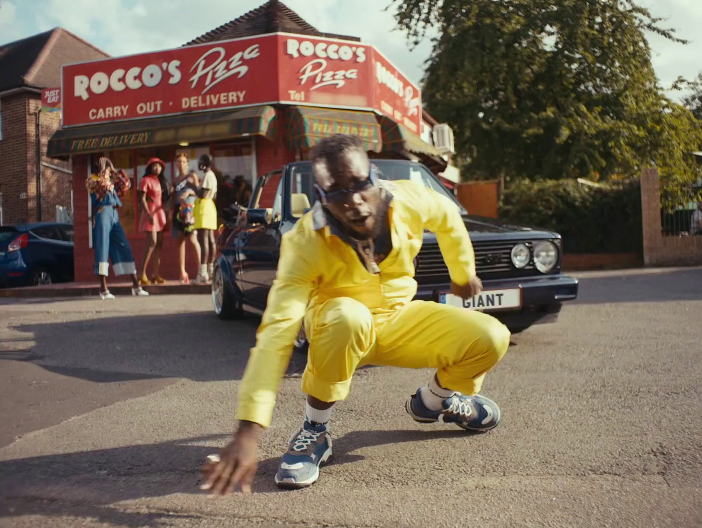 a man in yellow is doing a trick on the street