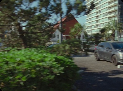 a car driving down a street next to tall buildings