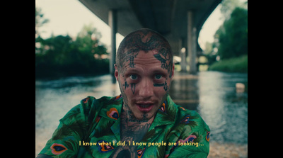 a man with tattoos on his face and neck