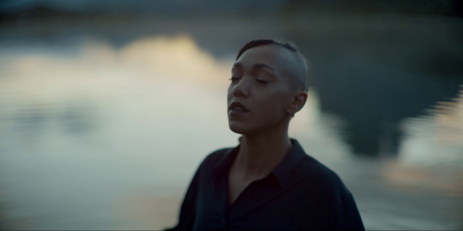 a woman standing in front of a body of water