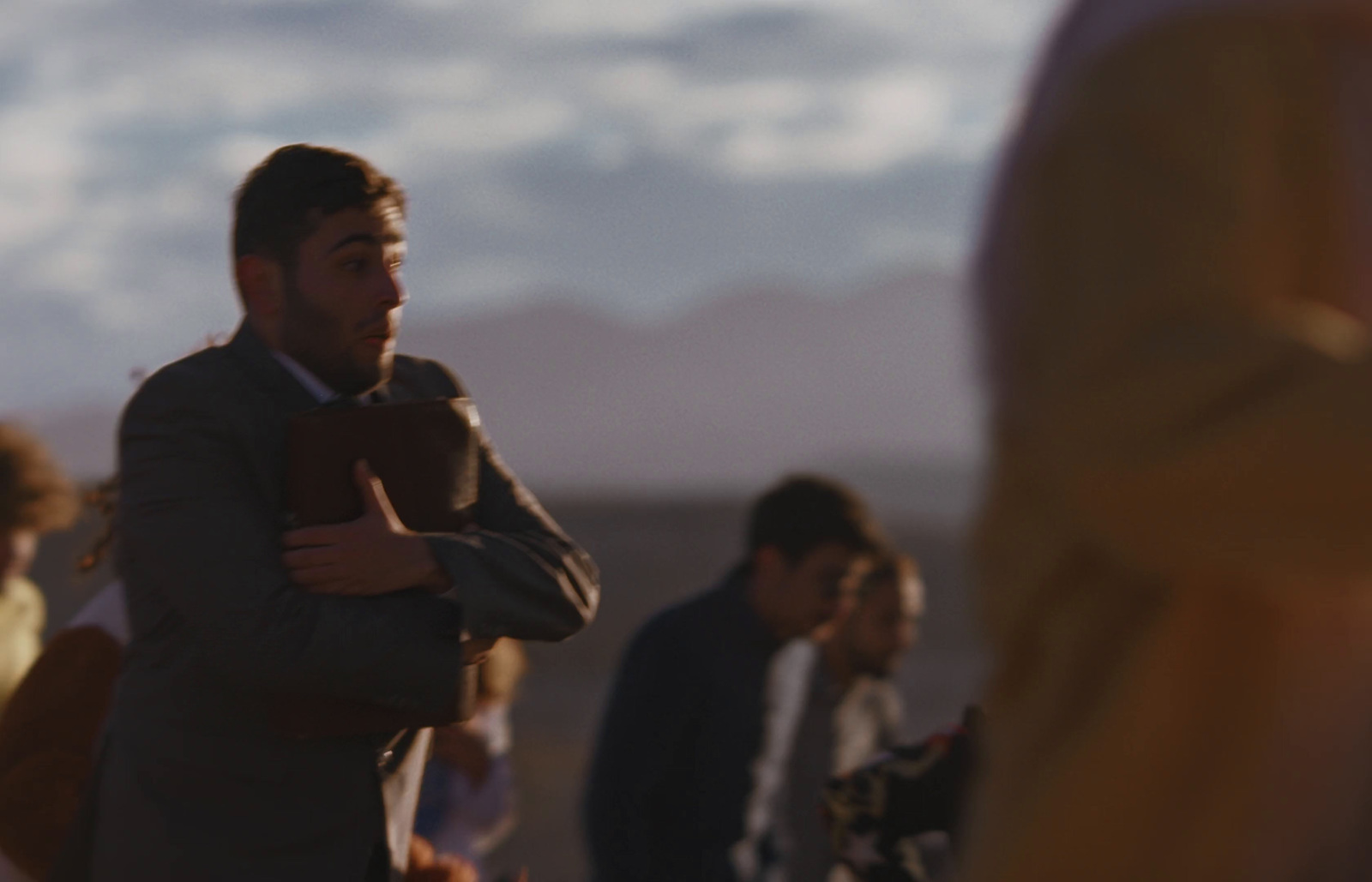 a man in a suit standing in front of a group of people