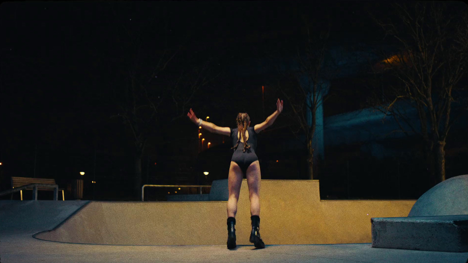 a woman standing on a skateboard at night