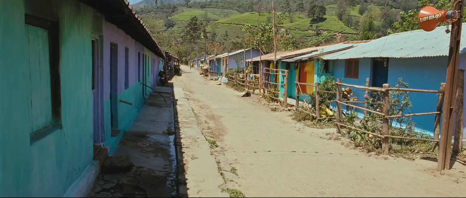 a dirt road with a bunch of houses on the side of it