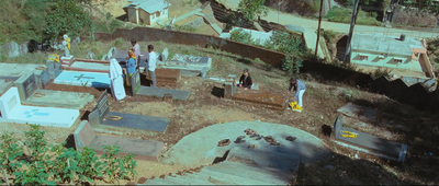 a group of people standing around a cemetery