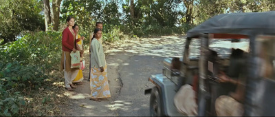 a couple of women walking down a dirt road