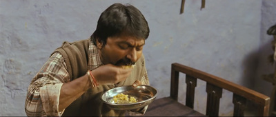 a man eating food out of a silver bowl