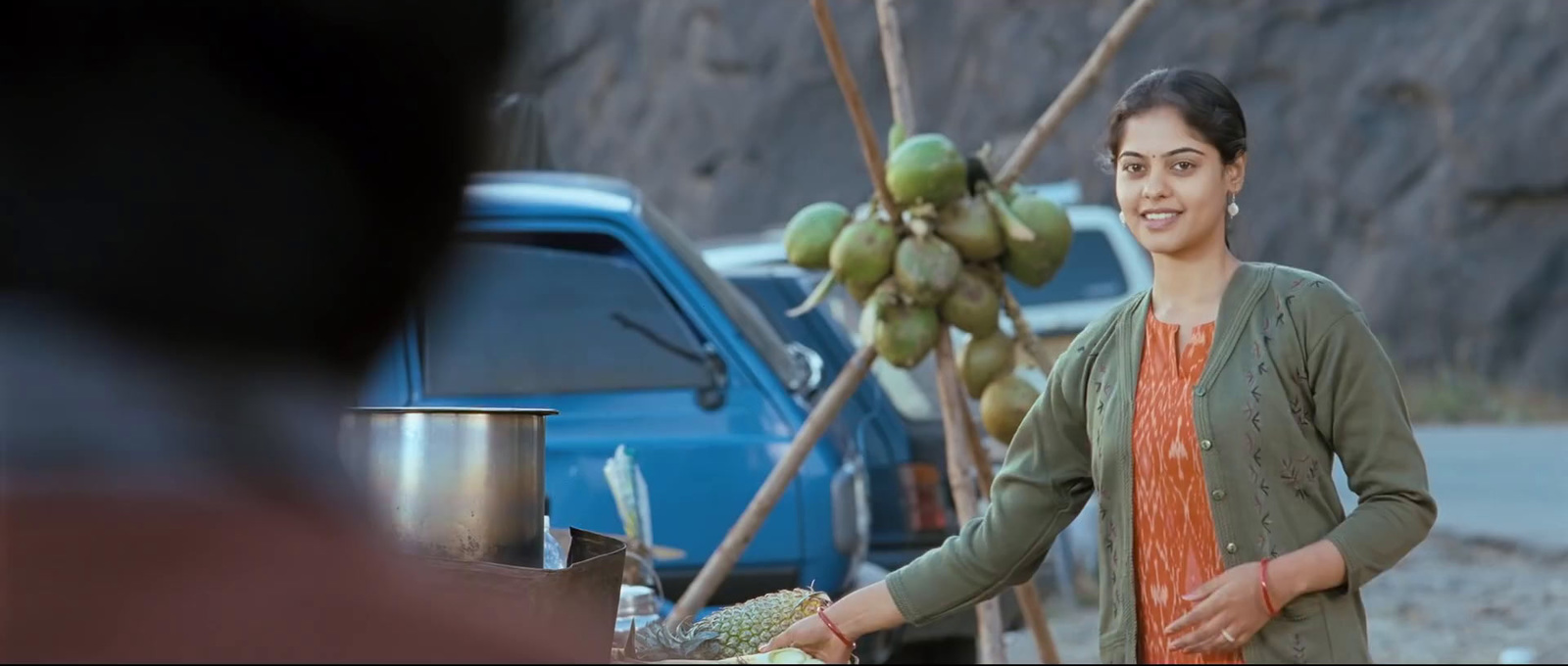 a woman standing next to a bunch of fruit