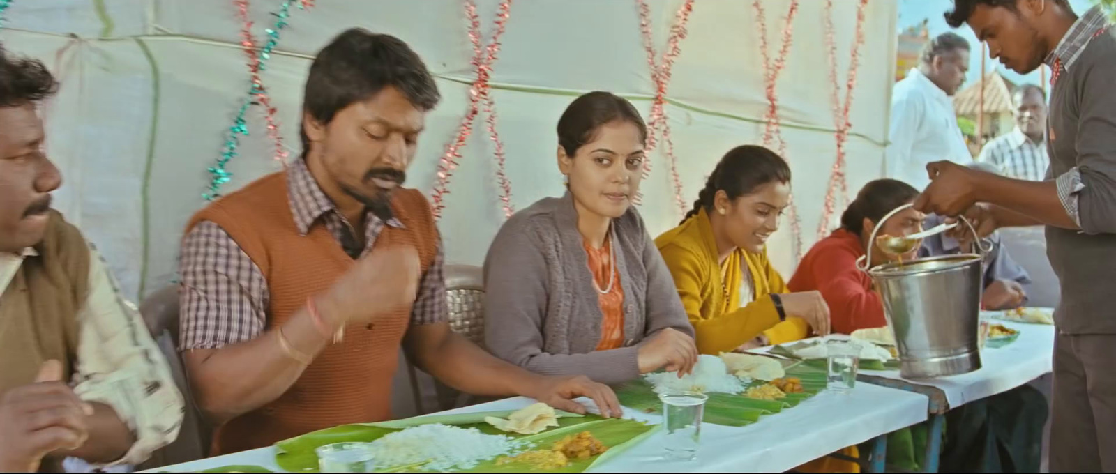 a group of people sitting at a table eating food