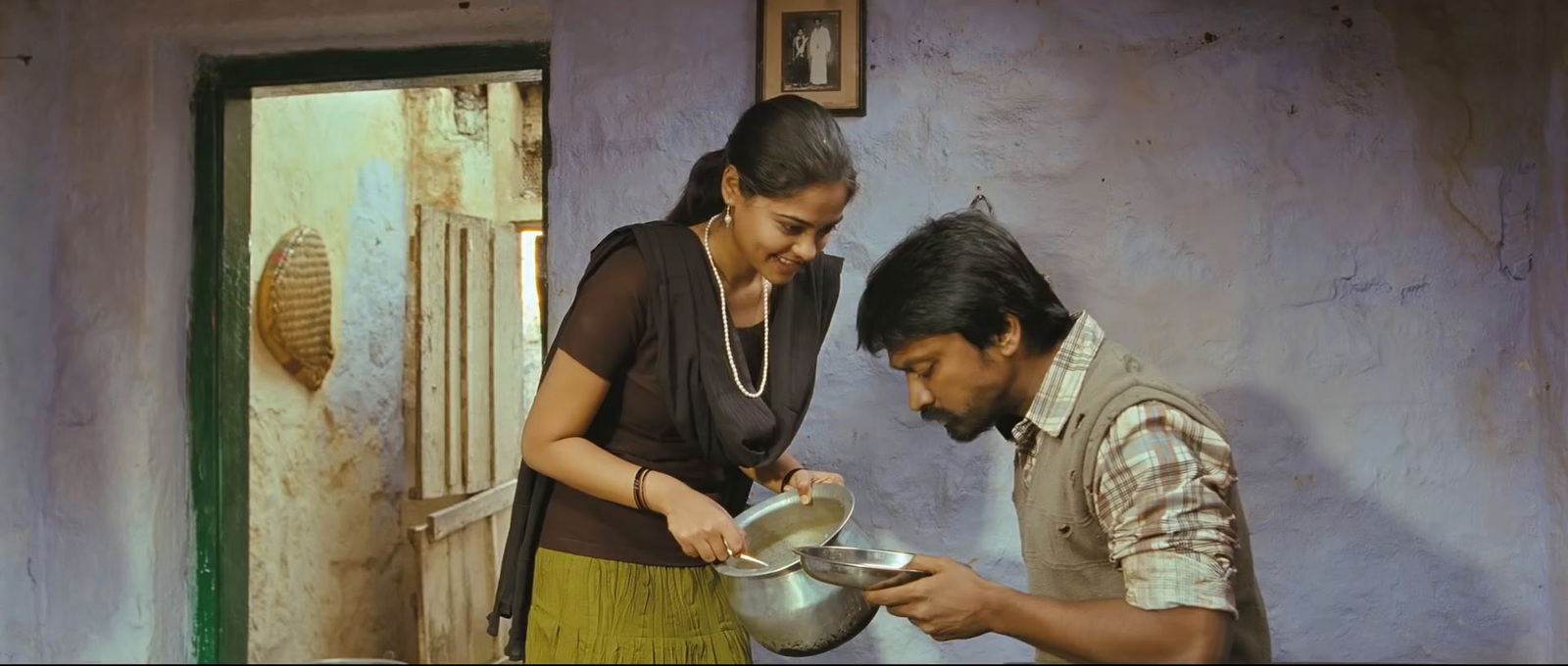 a man standing next to a woman pouring water