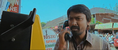 a man talking on a cell phone in a crowded street