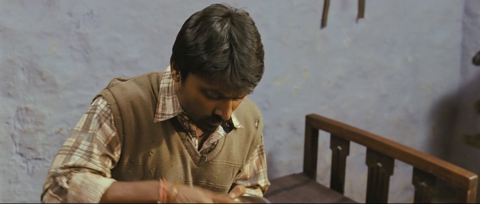 a man sitting at a table writing on a piece of paper