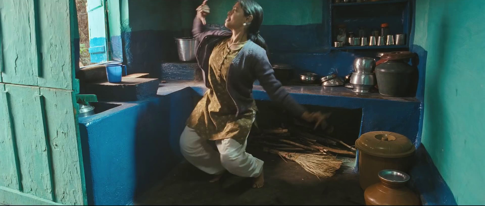 a woman standing in a kitchen next to a stove