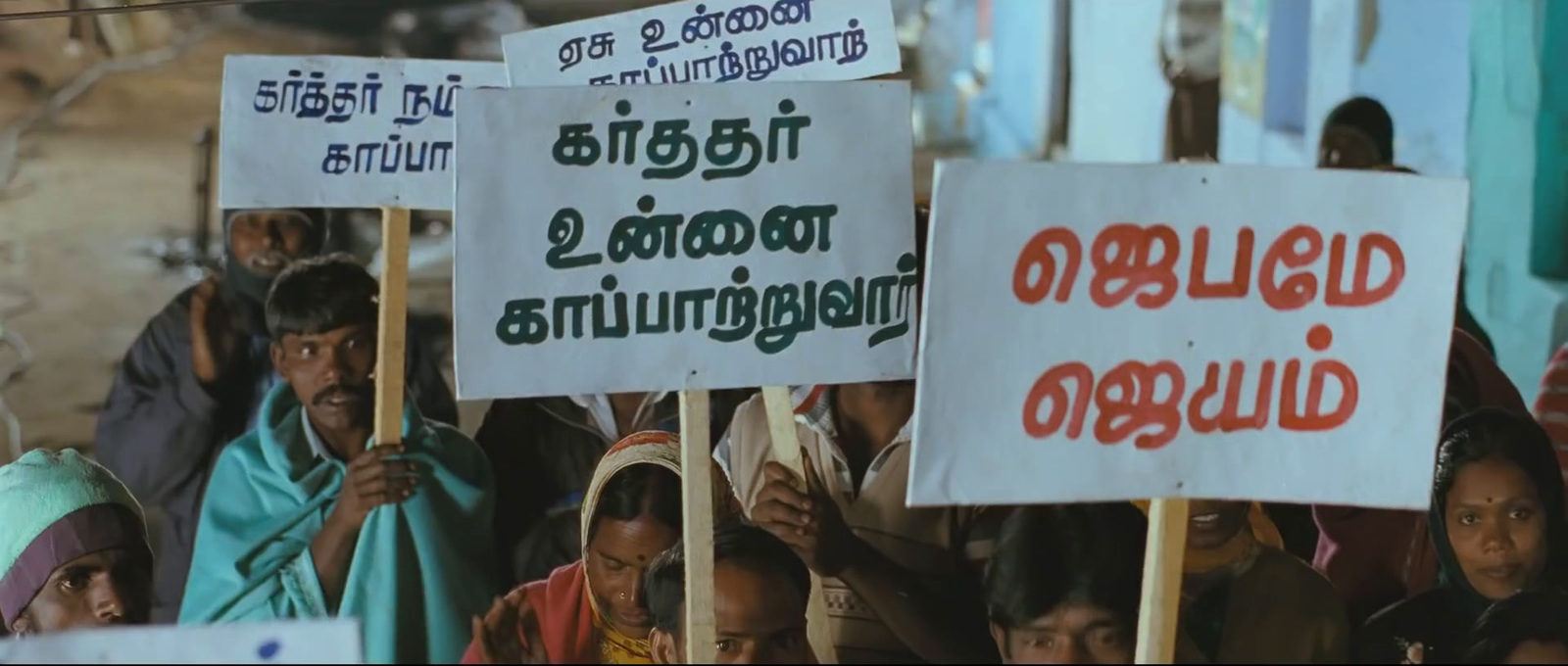 a group of people holding signs in front of a building